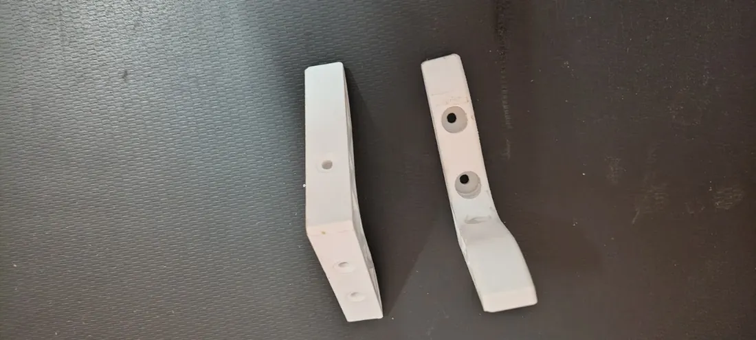 Pair of white 3D printed prototype brackets