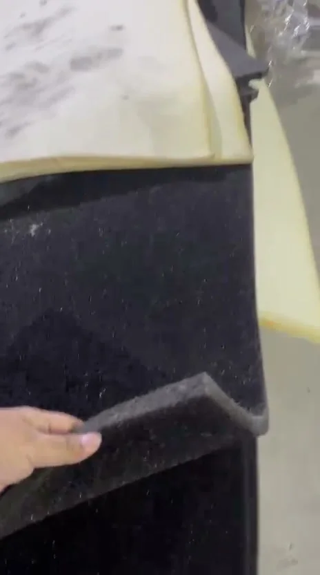 A sheet of reticulated foam lifted by hand to show its cut thickness and open-cell edge