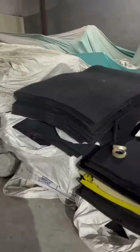 Cut sheets of black reticulated foam stacked in the workshop ready for die-cutting